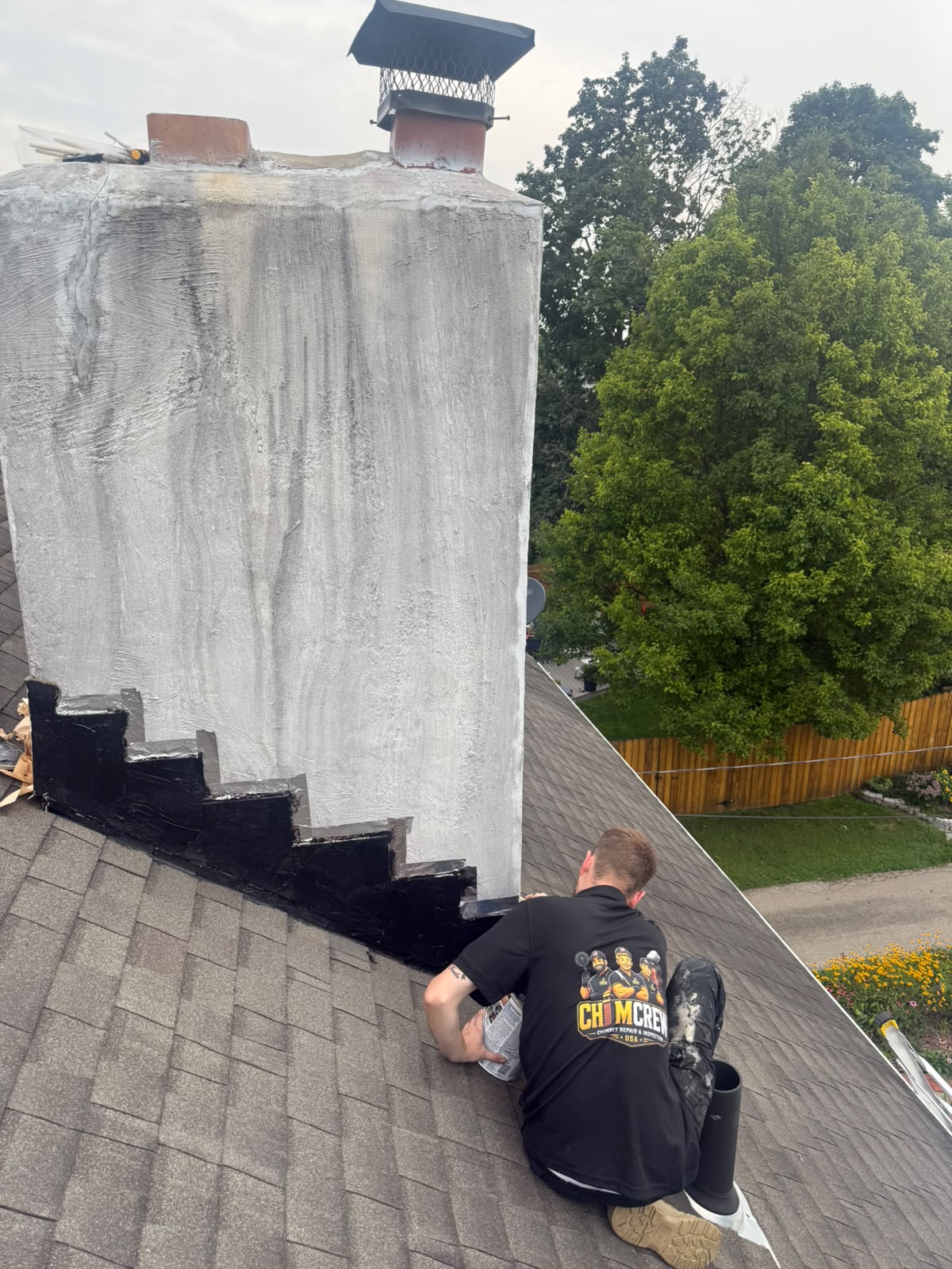 ChimCrew crew member waterproofing a chimney and sealing flashing