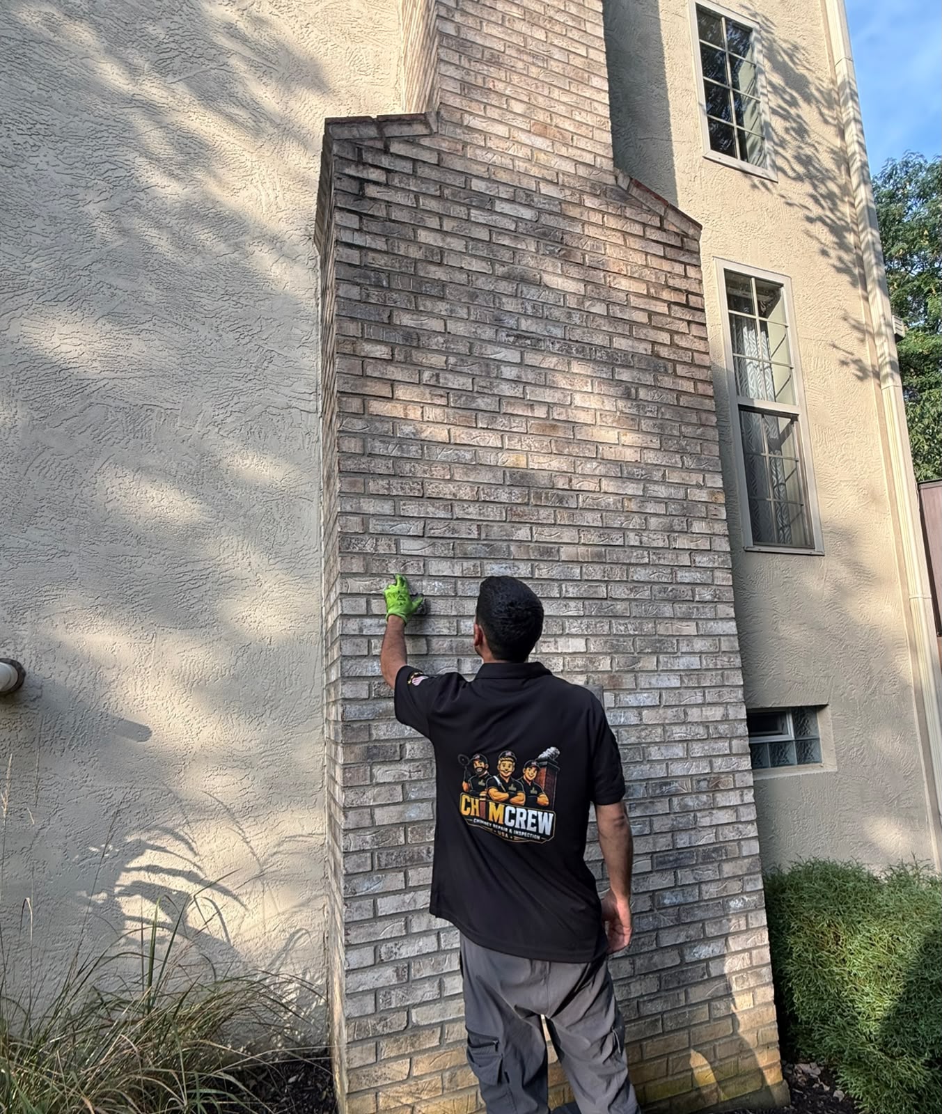 ChimCrew technician inspecting exterior chimney brickwork