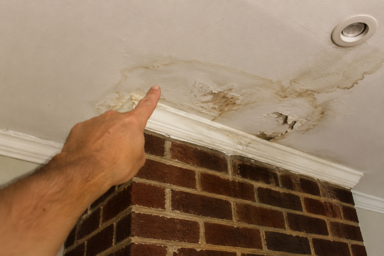 Water stain and ceiling damage caused by a leaking chimney
