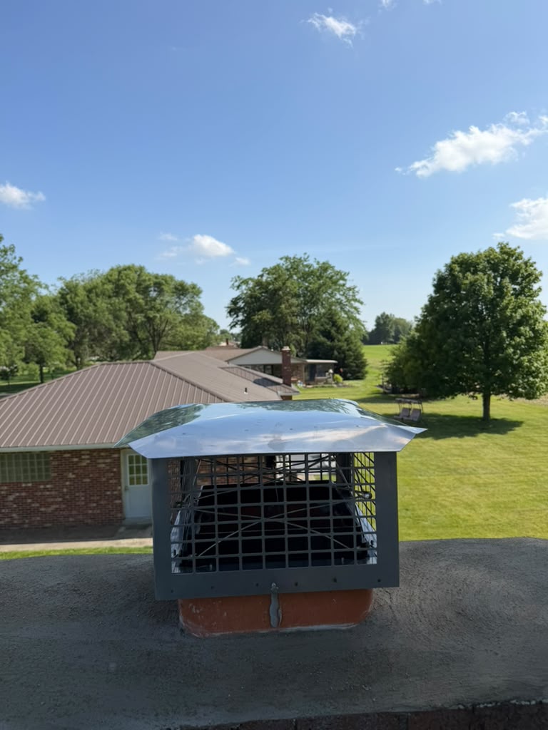 Close-up of installed mesh chimney cap on a brick stack